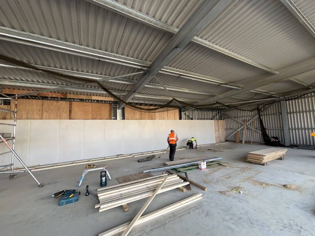 Workers installing passive fire protection barriers in UK hanger unit